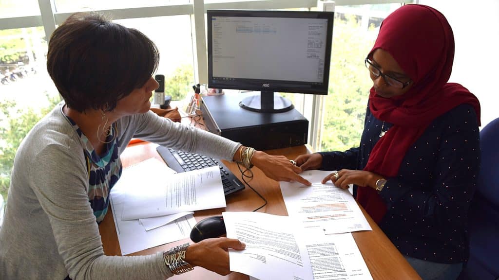 Consultation Profil+ : une conseillère accompagne une personne migrante qualifiée pour adapter son dossier de candidature et valoriser son parcours professionnel en Suisse.