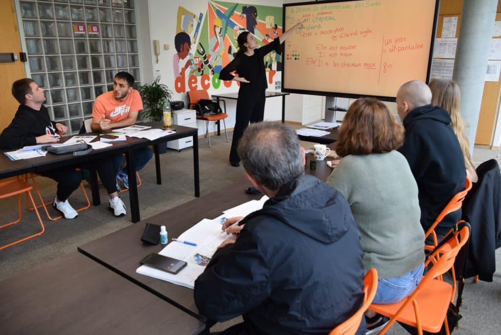 Des apprenant·e·s suivent un cours de français à l'association découvrir