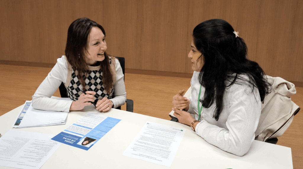 Une femme migrante qualifiée échange avec une professionnelle de son domaine lors d’un entretien d’information